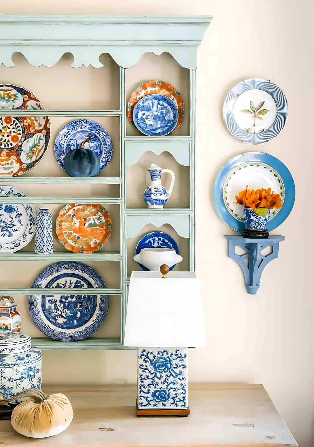 blue plate rack above a white sideboard decorated with blue and orange plates for fall