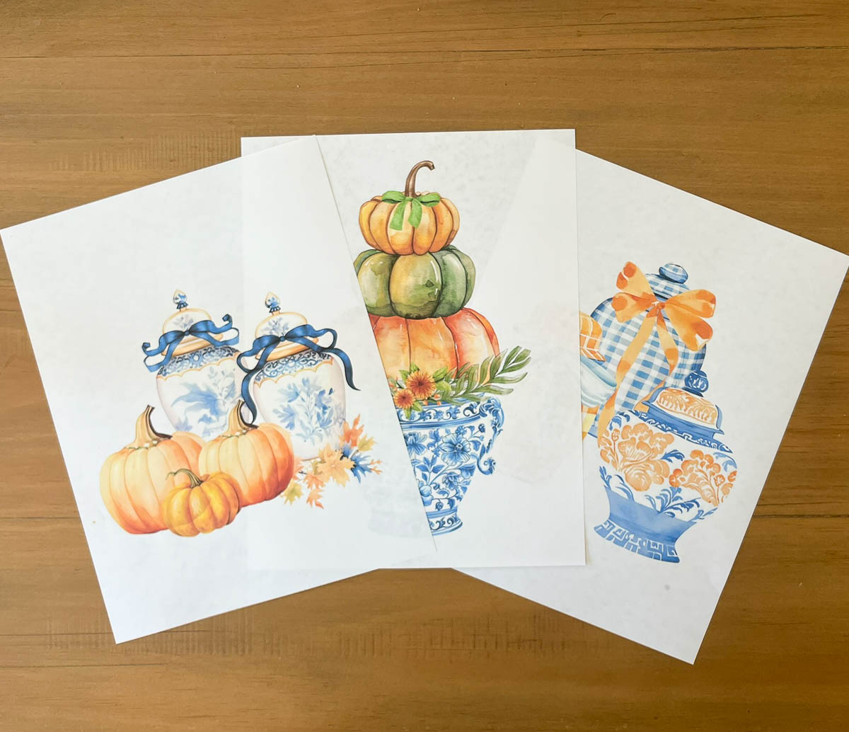 3 free fall printables lying in a group on a wood table