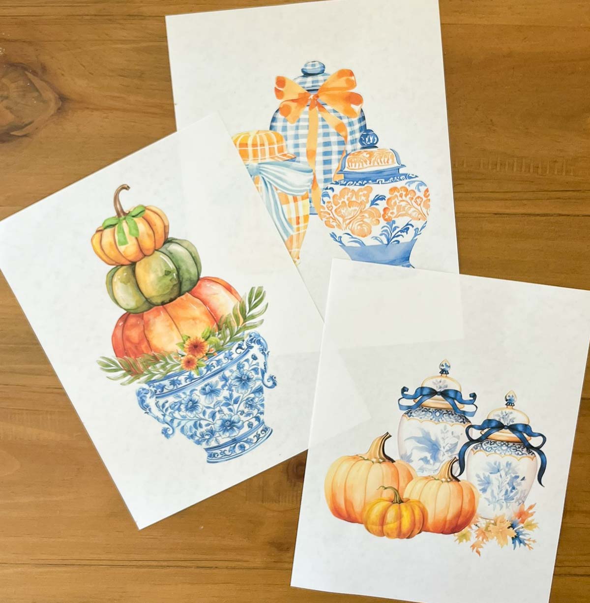 3 free fall printables lying in a group on a wood table