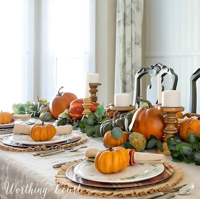 Thanksgiving tablescape with neutral linens, pumpkins and green eucalyptus