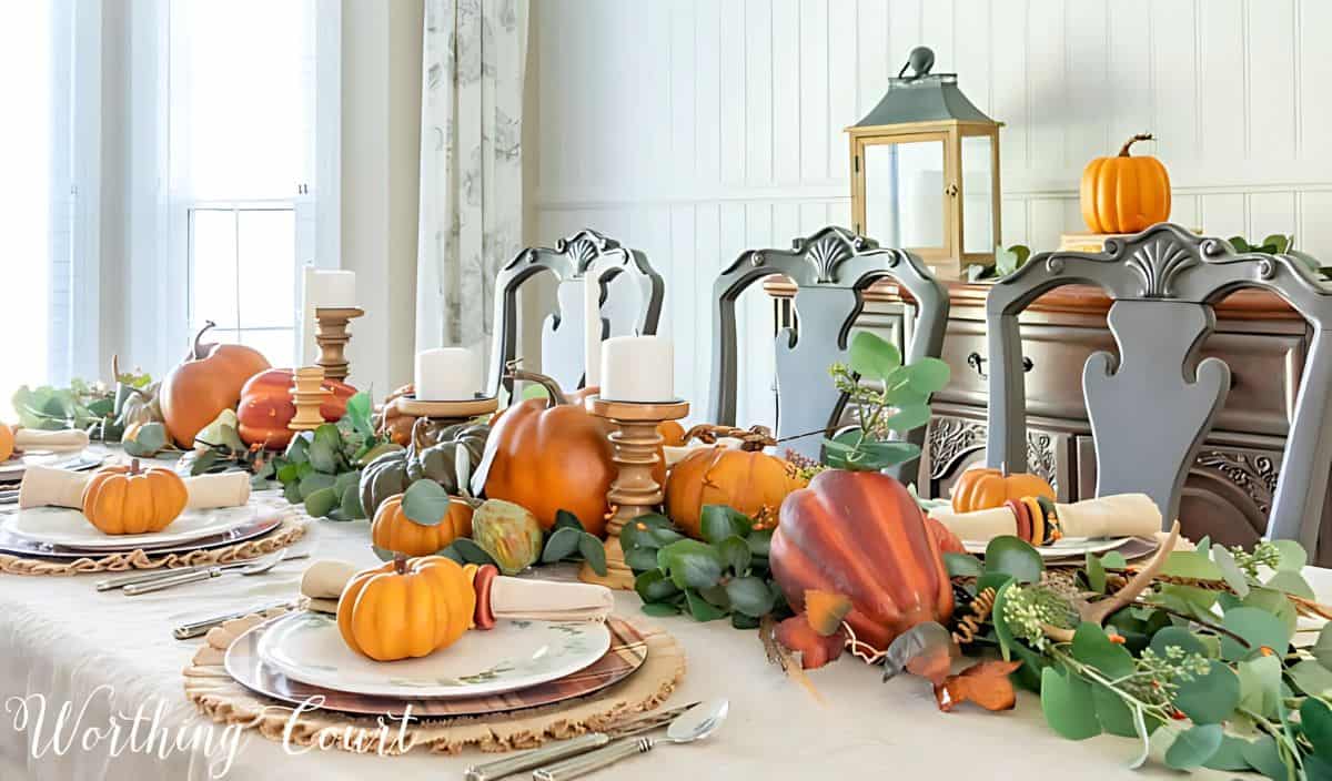 Thanksgiving tablescape with neutral linens, pumpkins and green eucalyptus