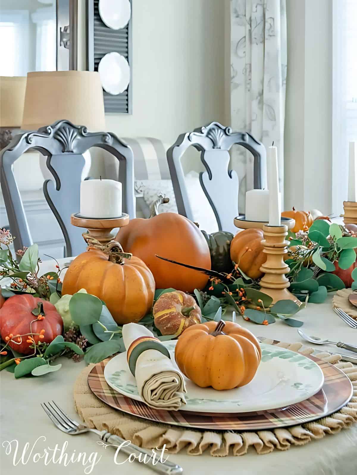 Thanksgiving tablescape with neutral linens, pumpkins and green eucalyptus