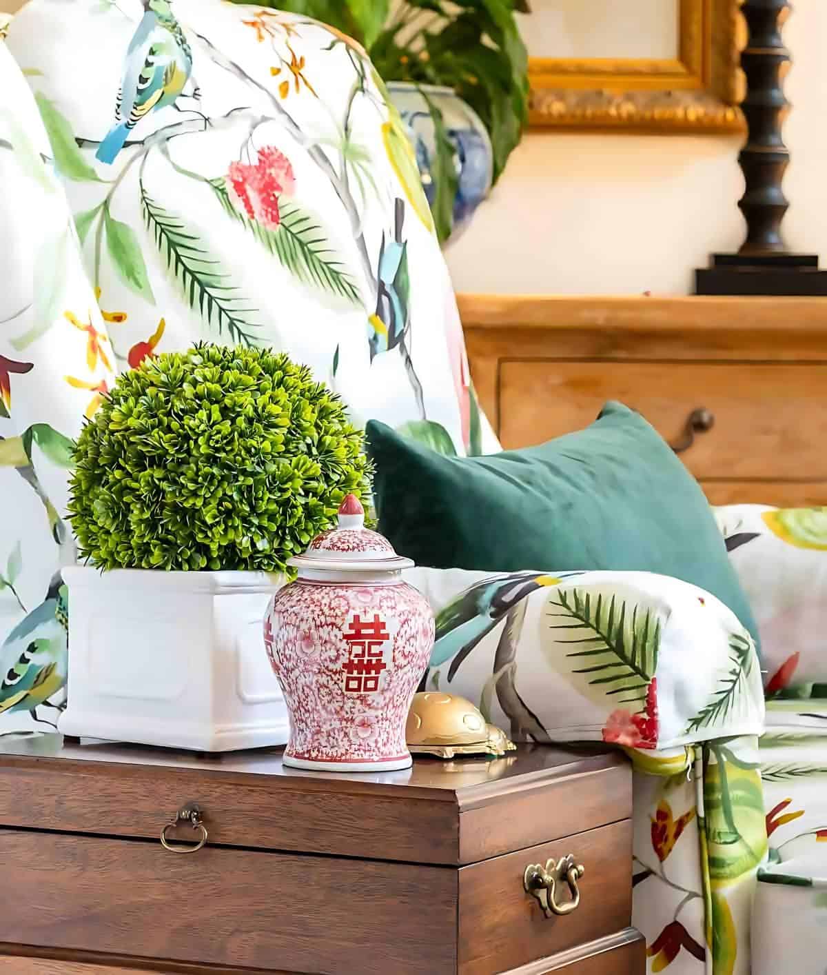 fall vignette on a wood table beside a floral upholstered arm chair