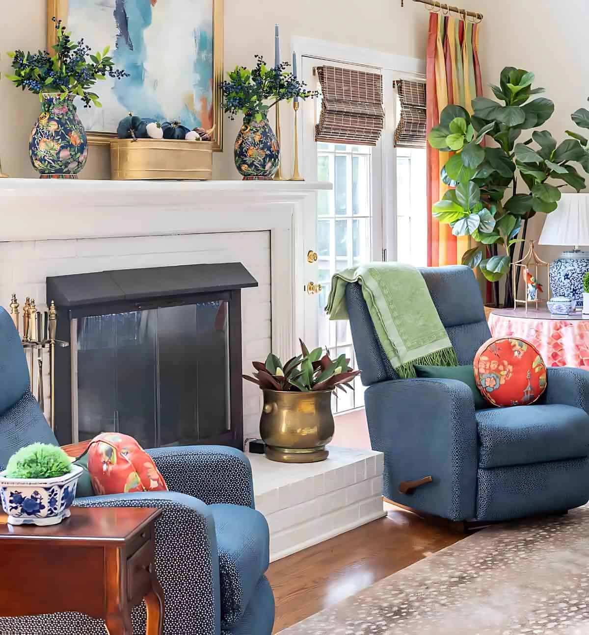 two blue recliners flanking a white brick fireplace decorated with blankets, pillows and accessories for fall