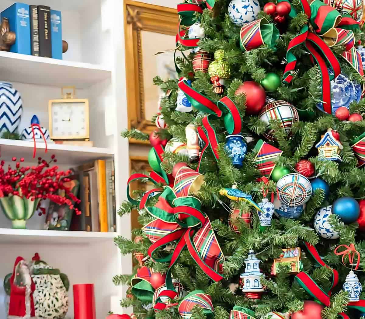 Chinoiserie Christmas tree decorated with red and green ornaments and blue and white Chinoiserie ornaments and tartan plaid ribbon