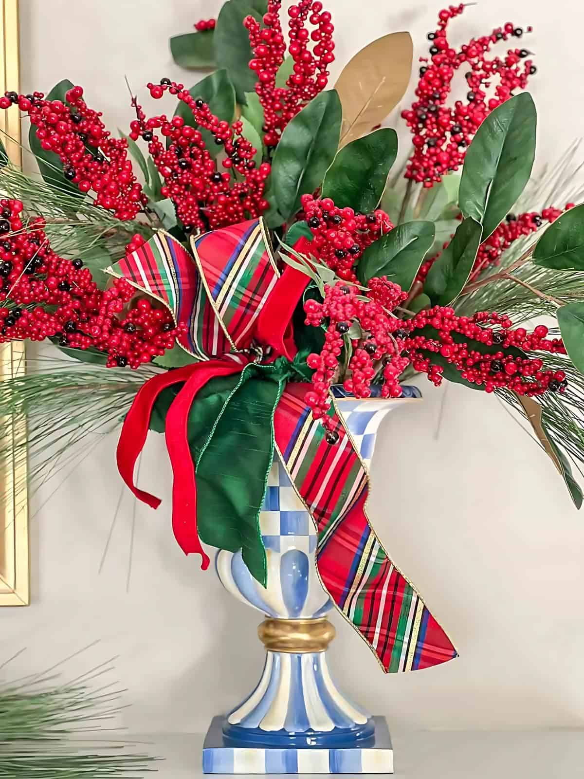 blue and white urn filled with Christmas greenery and plaid ribbon