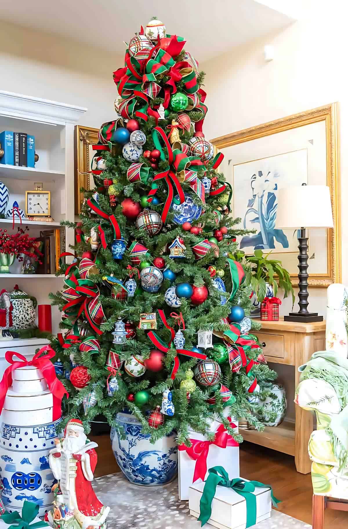 Chinoiserie Christmas tree decorated with red and green ornaments and blue and white Chinoiserie ornaments and tartan plaid ribbon