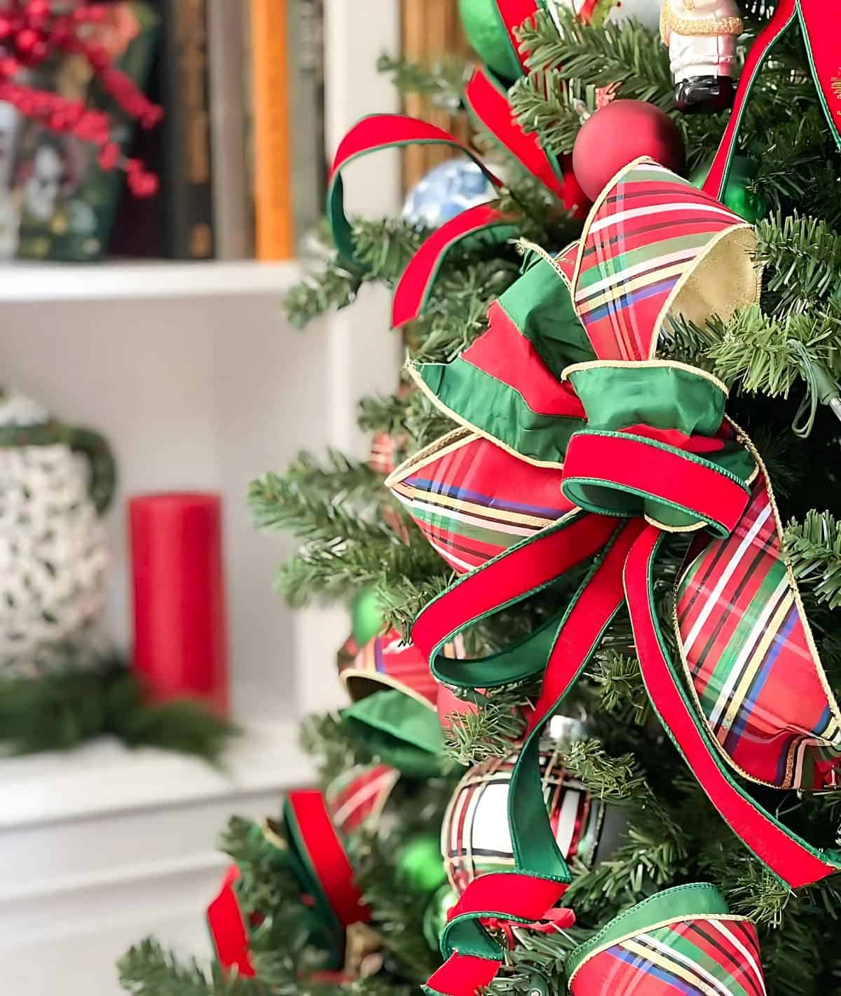 Chinoiserie Christmas tree decorated with red and green ornaments and blue and white Chinoiserie ornaments and tartan plaid ribbon