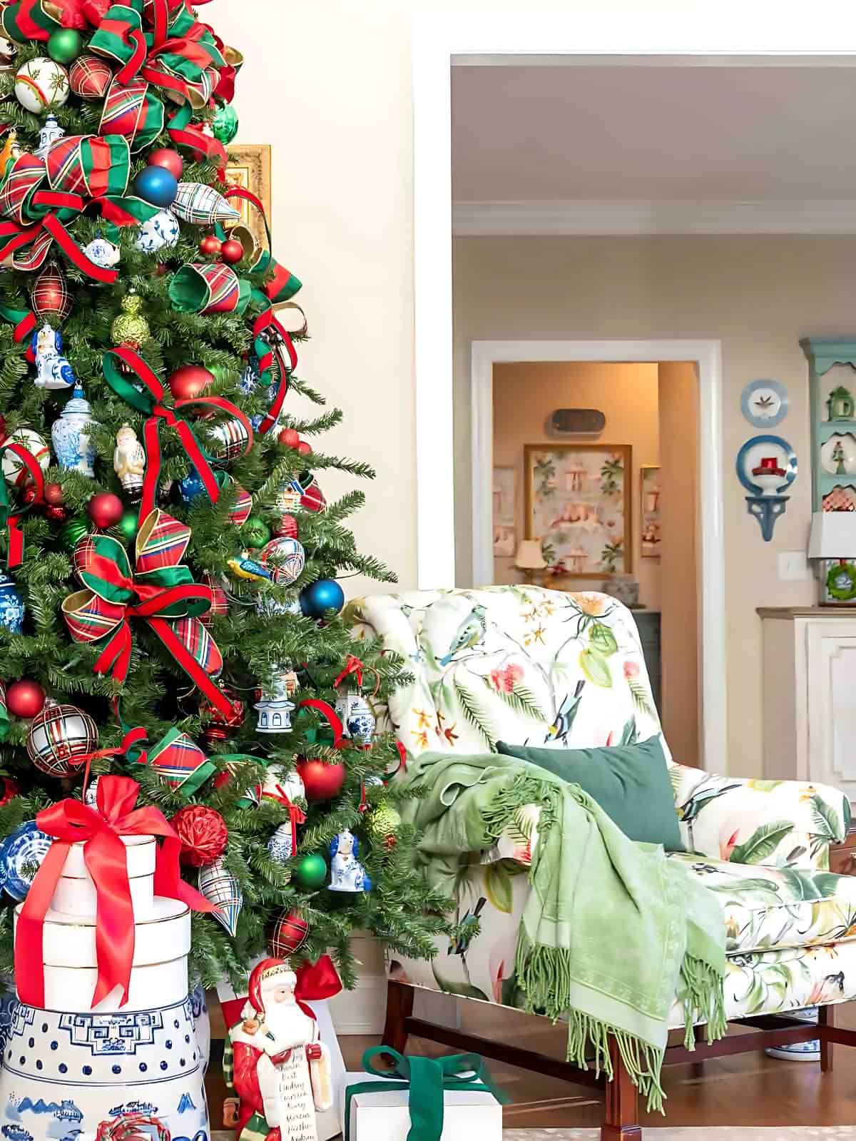 Chinoiserie Christmas tree decorated with red and green ornaments and blue and white Chinoiserie ornaments and tartan plaid ribbon