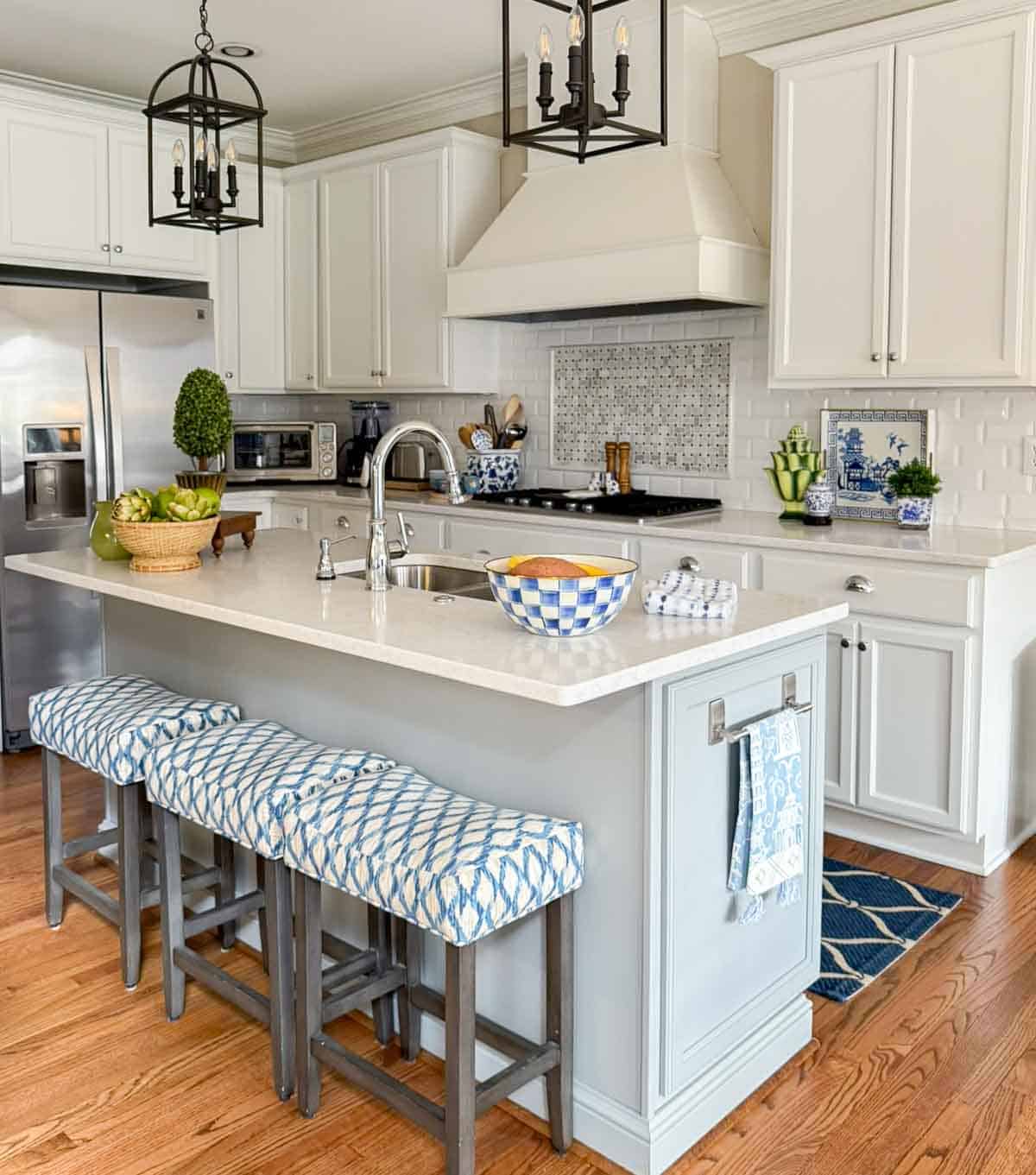 all white kitchen with a gray island and colorful accessories